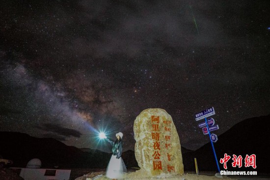 圖為6月20日晚，游客“打卡”西藏阿里暗夜公園，天上是銀河與流星（右上角）。曹枝清 攝