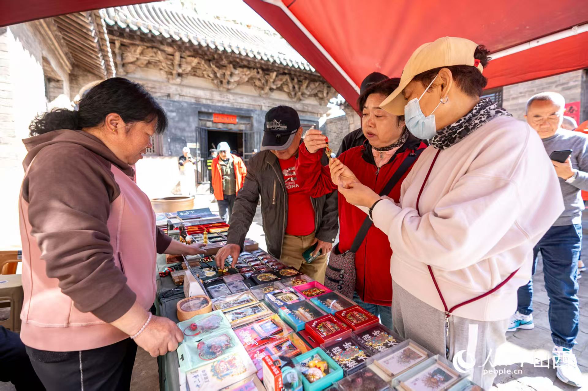 游客在山西省高平市鐵佛寺選購(gòu)文創(chuàng)產(chǎn)品。人民網(wǎng)記者 盧鵬宇攝