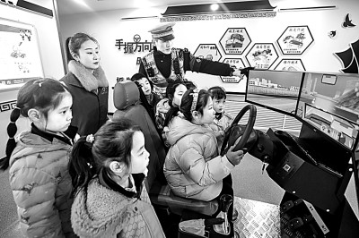 山東省榮成市公安局道路交通安全宣傳教育基地，交警帶領(lǐng)小學(xué)生現(xiàn)場(chǎng)體驗(yàn)?zāi)M駕駛。新華社發(fā)