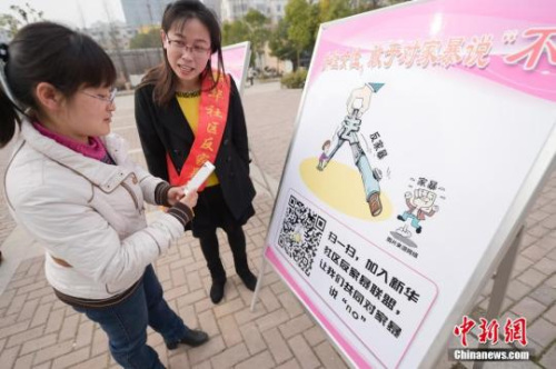 資料圖：今年3月8日，安徽合肥新華社區(qū)志愿者夏一瓊(右)向市民普及反家暴相關(guān)法律知識。鐘欣 攝